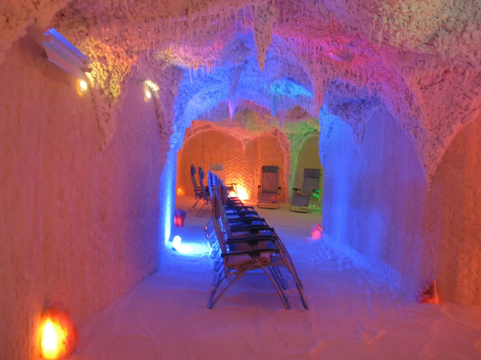 Innenraum einer Salzgrotte mit Liegestühlen und farbigem Licht